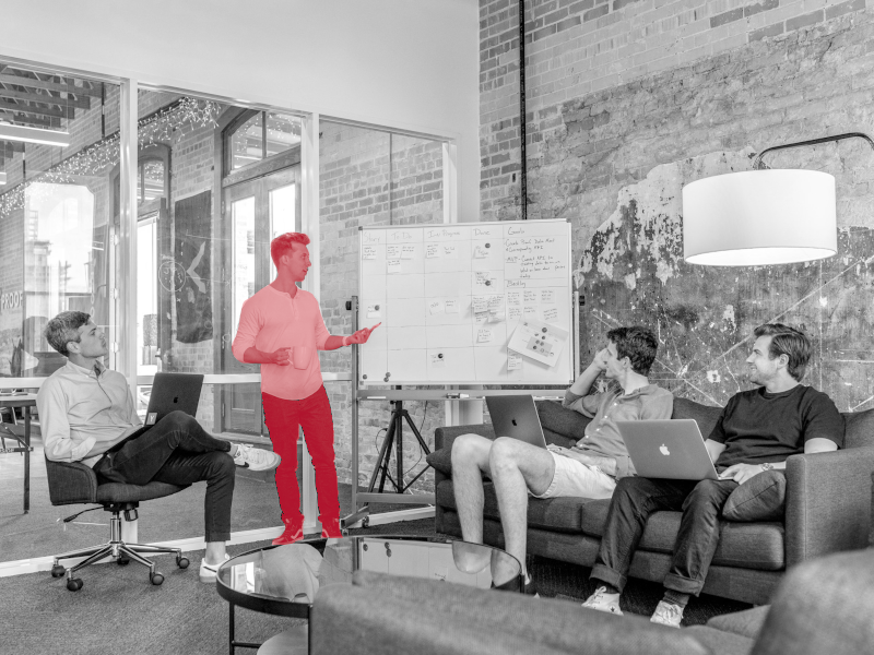 Un homme montre des dessins sur un tableau